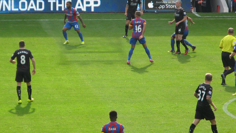 Dwight Gayle waits hopefully while Wilfried Zaha looks on.