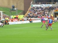 Wolves play the ball into a dangerous area, and Palace attempt to clear.