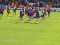 Cheerleaders flash their pom poms