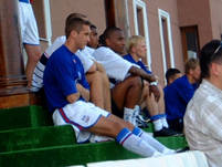 Some of the players watch the match from the side
